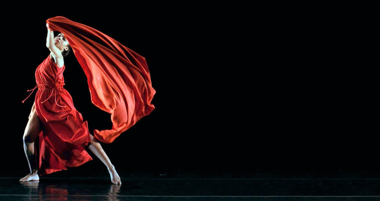 Woman on stage dancing in a dark theater